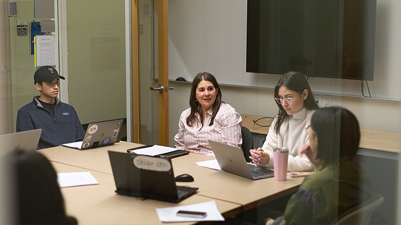 Professor Jen Doty and students sitting at a table doing lab work