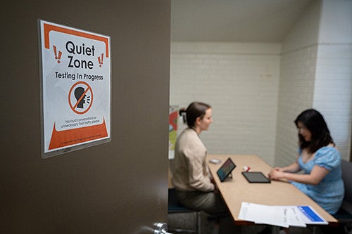 Two individuals sitting at a table inside the HEDCO Clinic