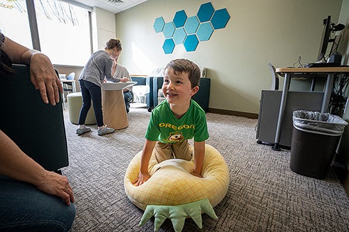 Child kneeling on a puffy pillow inside the HEDCO Clinic