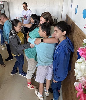 Ellie Hein hugging a group of students in a Costa Rica classroom