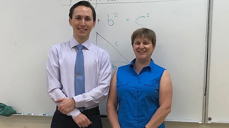 student teacher and mentor standing in a classroom posing for a photo
