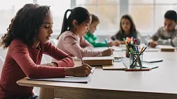 individual students looking downwards as they work at desks