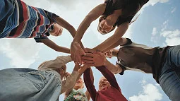 group of individuals piling hands