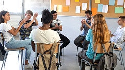 group sitting in a circle clapping their hands