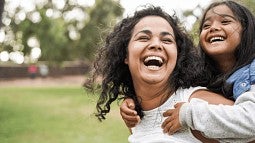 mother with child on her back both laughing