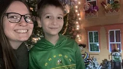 Logan Holley Luna and son posing with holiday decorations in the background
