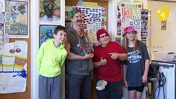 Mike Seager and Eugene 4J students posing in a classroom with artwork in background