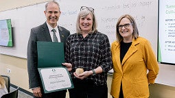 Alison Schmitke holding a Distinguished Teacher Award