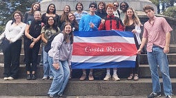 Ellie Hein with a group of individuals holding a Costa Rica flag banner