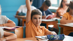 kid raising hand in school