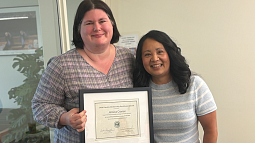 Jessica Cronce holding an award certificate next to Krista Chronister