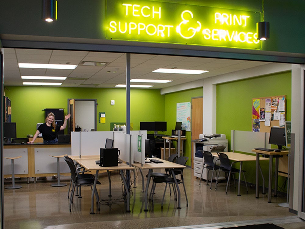 Tech Support & Print Services neon yellow sign and front entrance.