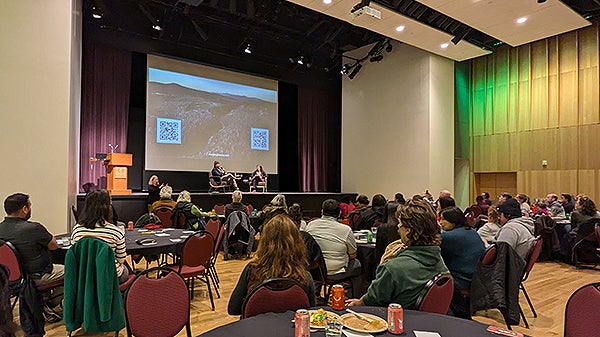 Dozens of people sitting in an auditorium for a presentation