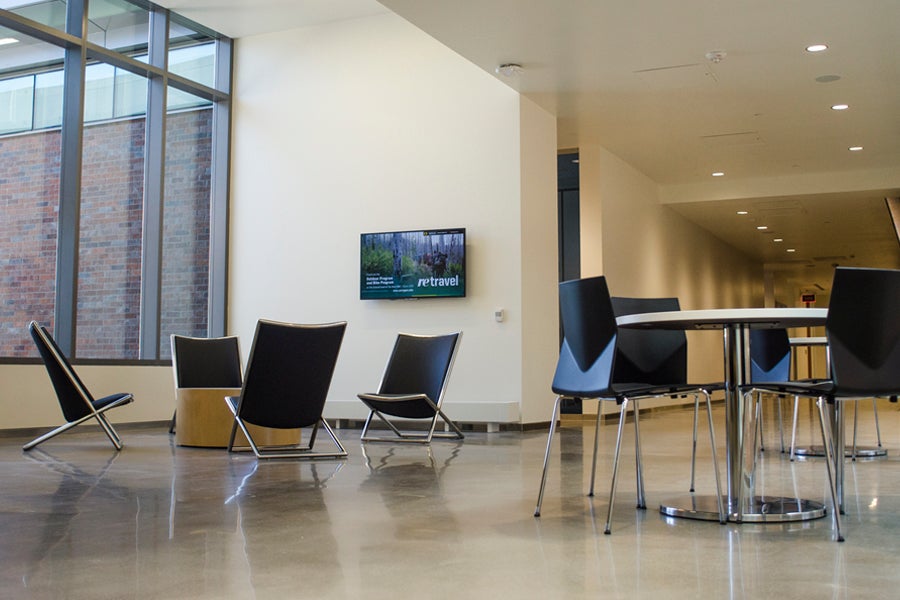 Empty lounge spaces with digital signage and device charging stations.