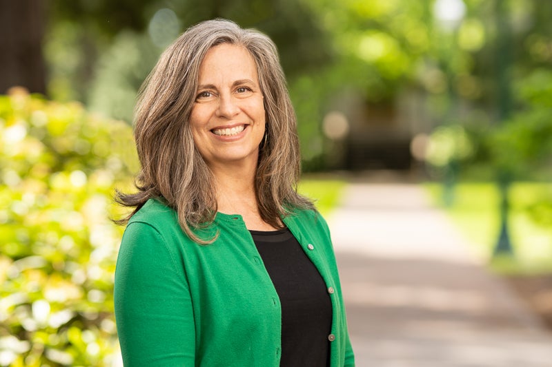 Michelle Holdway wearing a black top and a green sweater