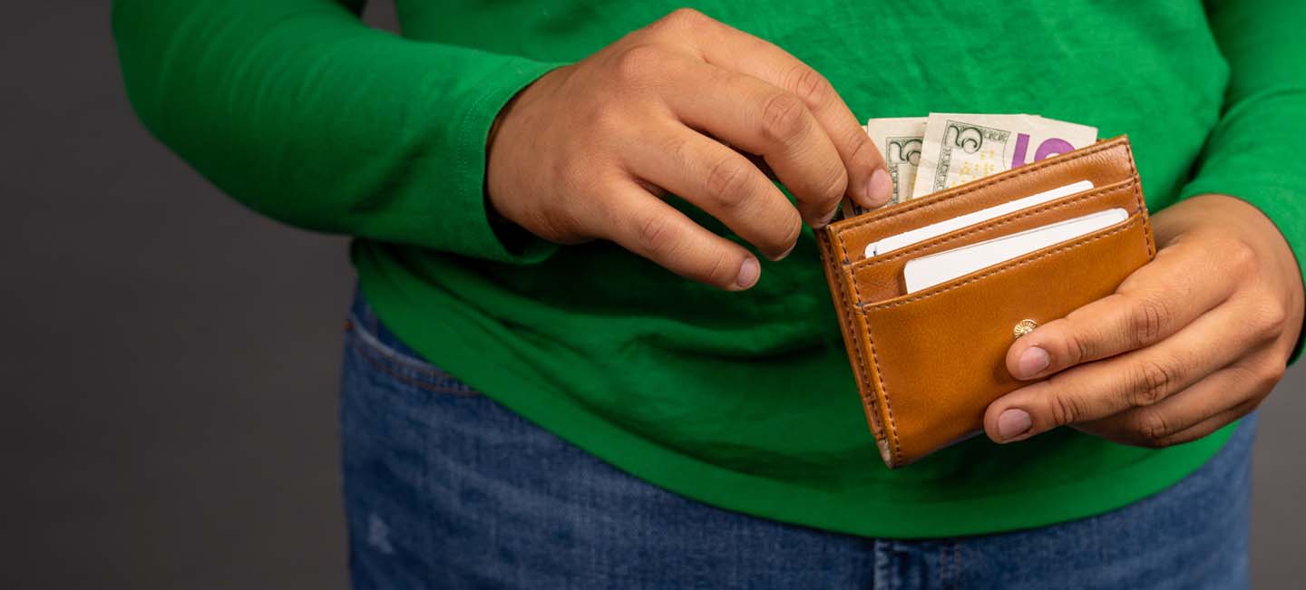 Student pulling money out of a wallet.