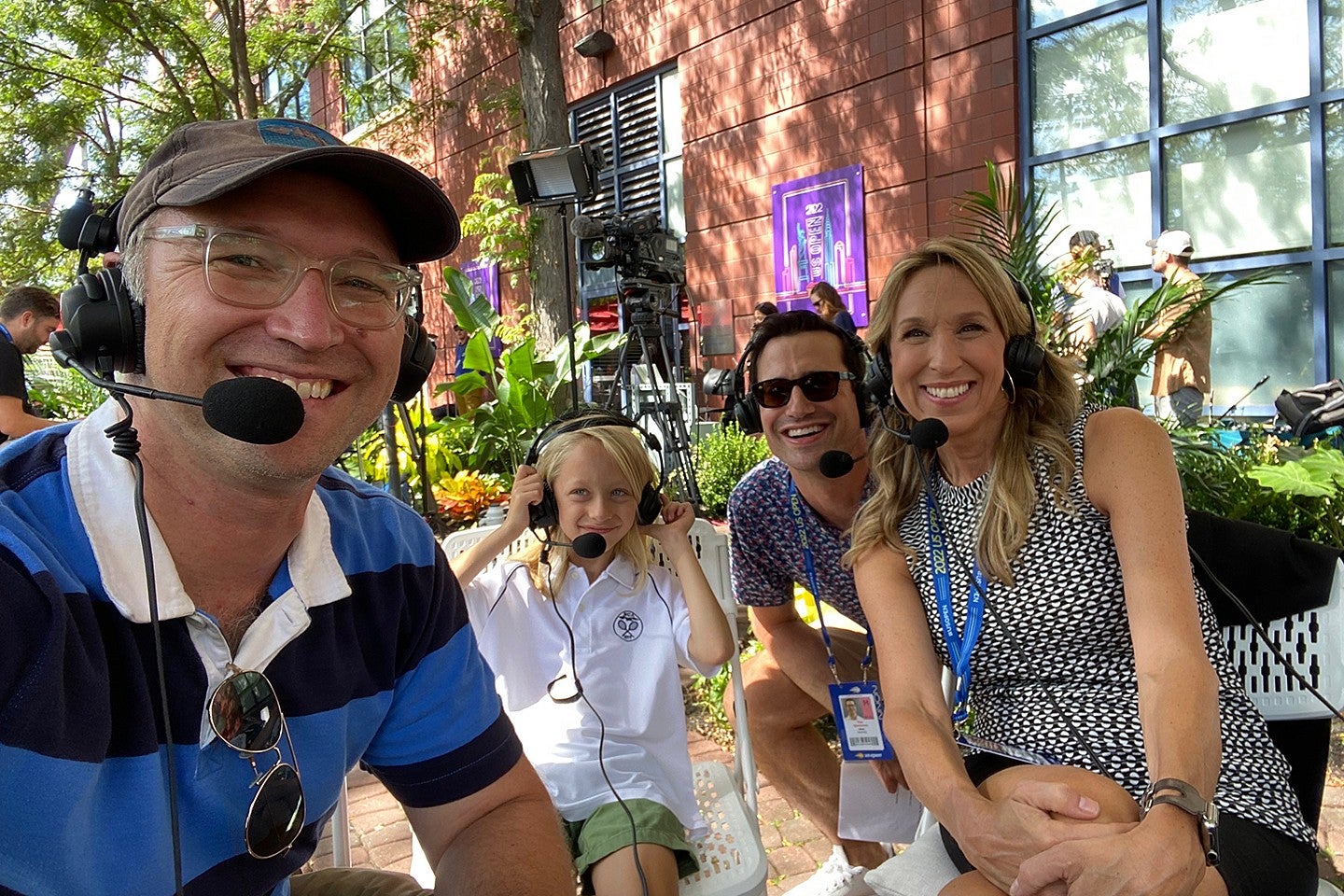 people in headsets seated outside at an event
