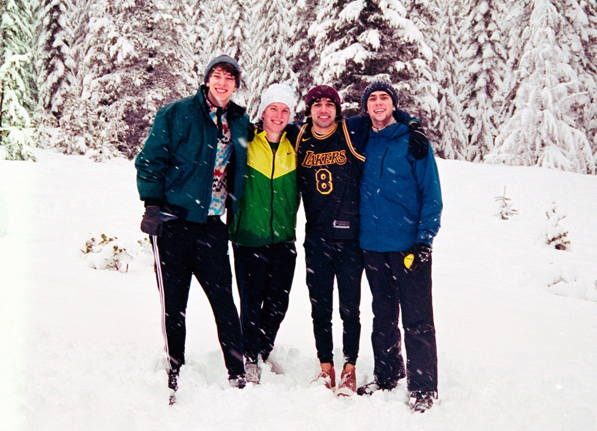 group of young men posing together in snowcovered landscape with fir trees