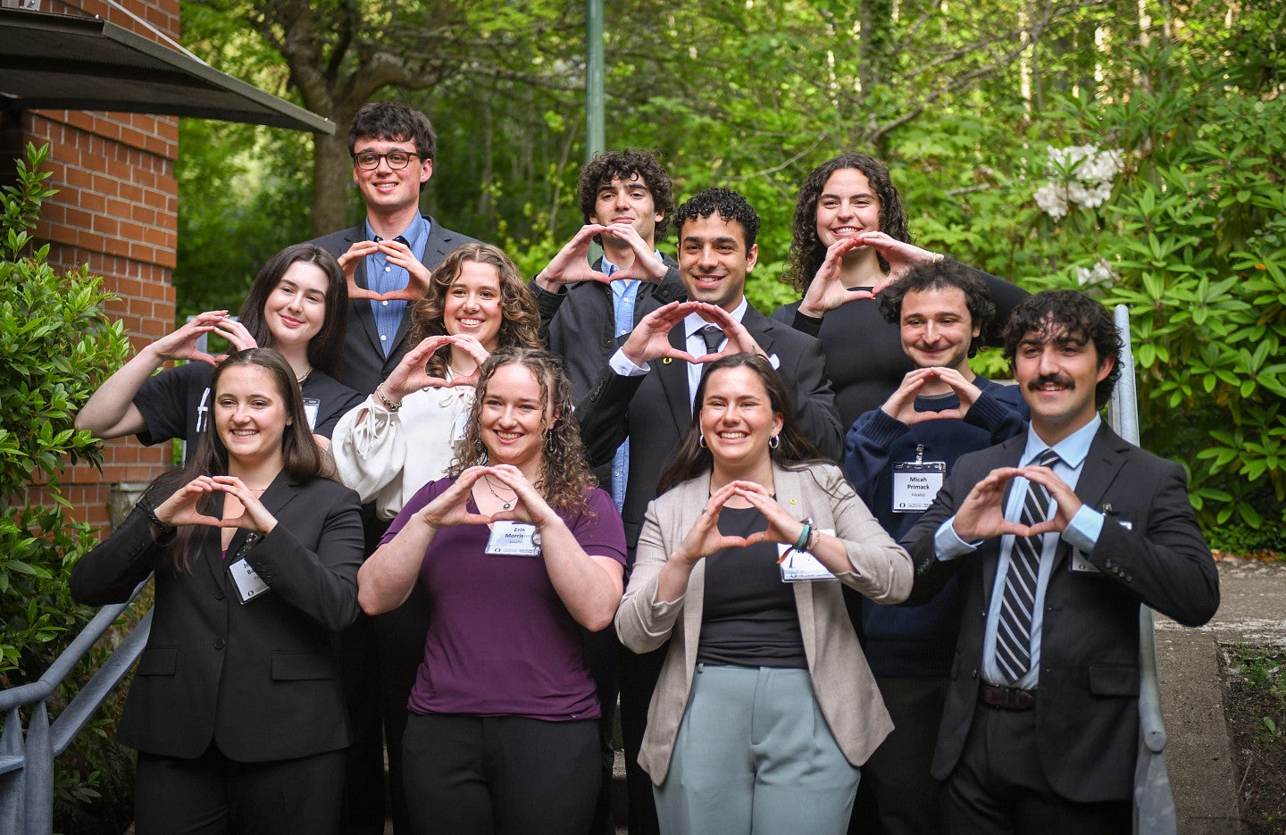 all 11 finalists in the 2026 three minute thesis competition posing together and throwing the O