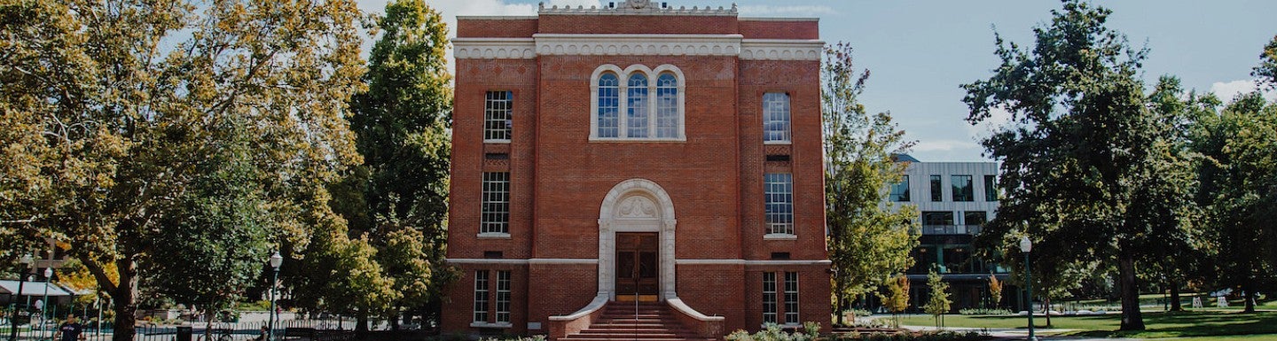 Chapman Hall seen from the west, surrounded by trees in late autumn.