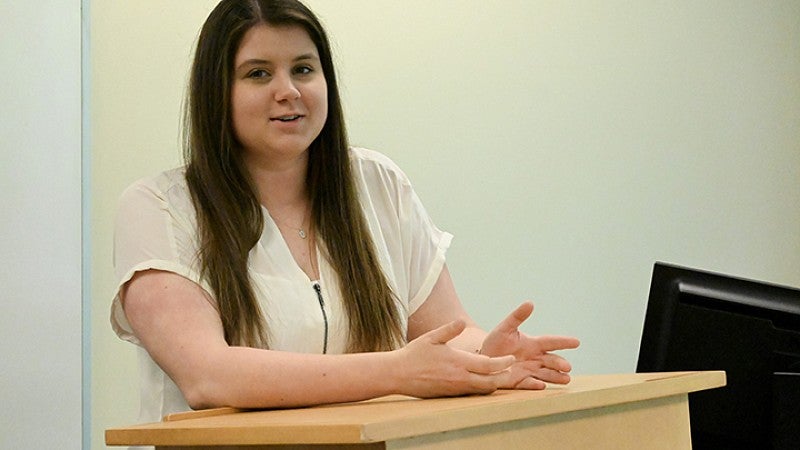 student speaking from podium in classroom