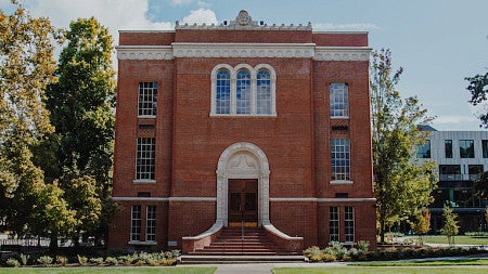 Chapman Hall seen from the west, surrounded by trees in late autumn.