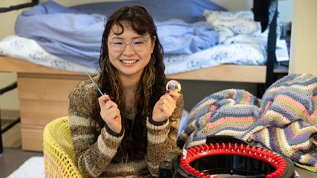 Emma Nazareno holds up crochet tools.