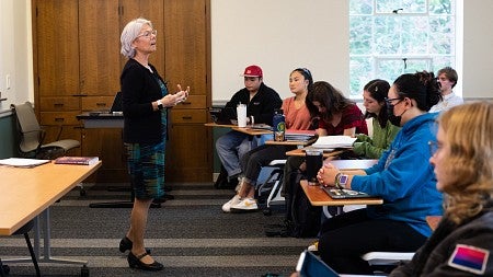 ellen fitzpatrick teaching at the front of a classroom