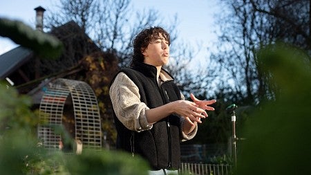 teddy clayton talking and gesturing on a sunny day at the urban farm