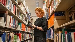 lizzy lerud browsing books in the Knight Library stacks