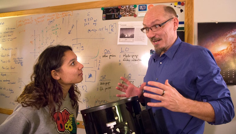 Faculty member and student talking in front of white board