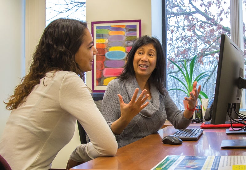 Faculty member helping student at a desk