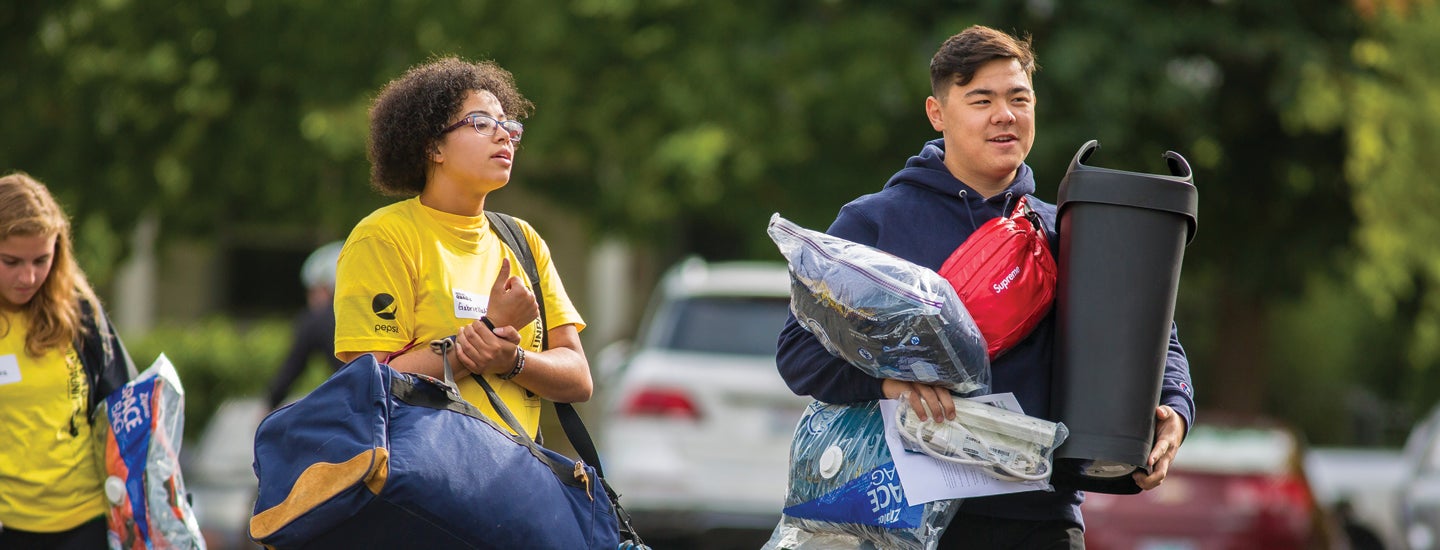 Volunteer helping incoming classmate move in to residence hall