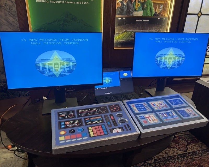 two computer monitors with spacecraft-style controls