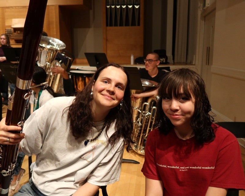 college student with bassoon and younger person