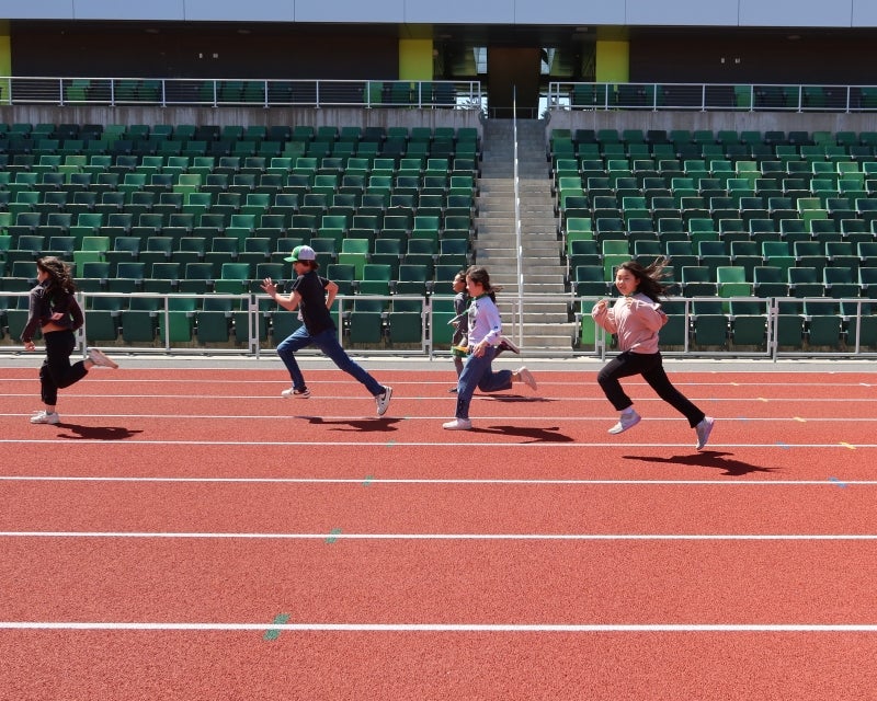 four children running on a track
