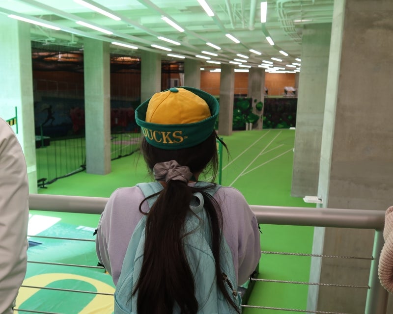 child in sailor hat that says Ducks looking at the track practice space