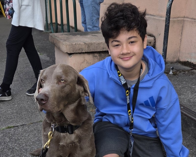 kid with UOPD dog Thor, who is a gray lab