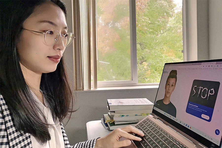 Tingyou Zou works at a laptop showing a chatbot designed to assist in smoking cessation