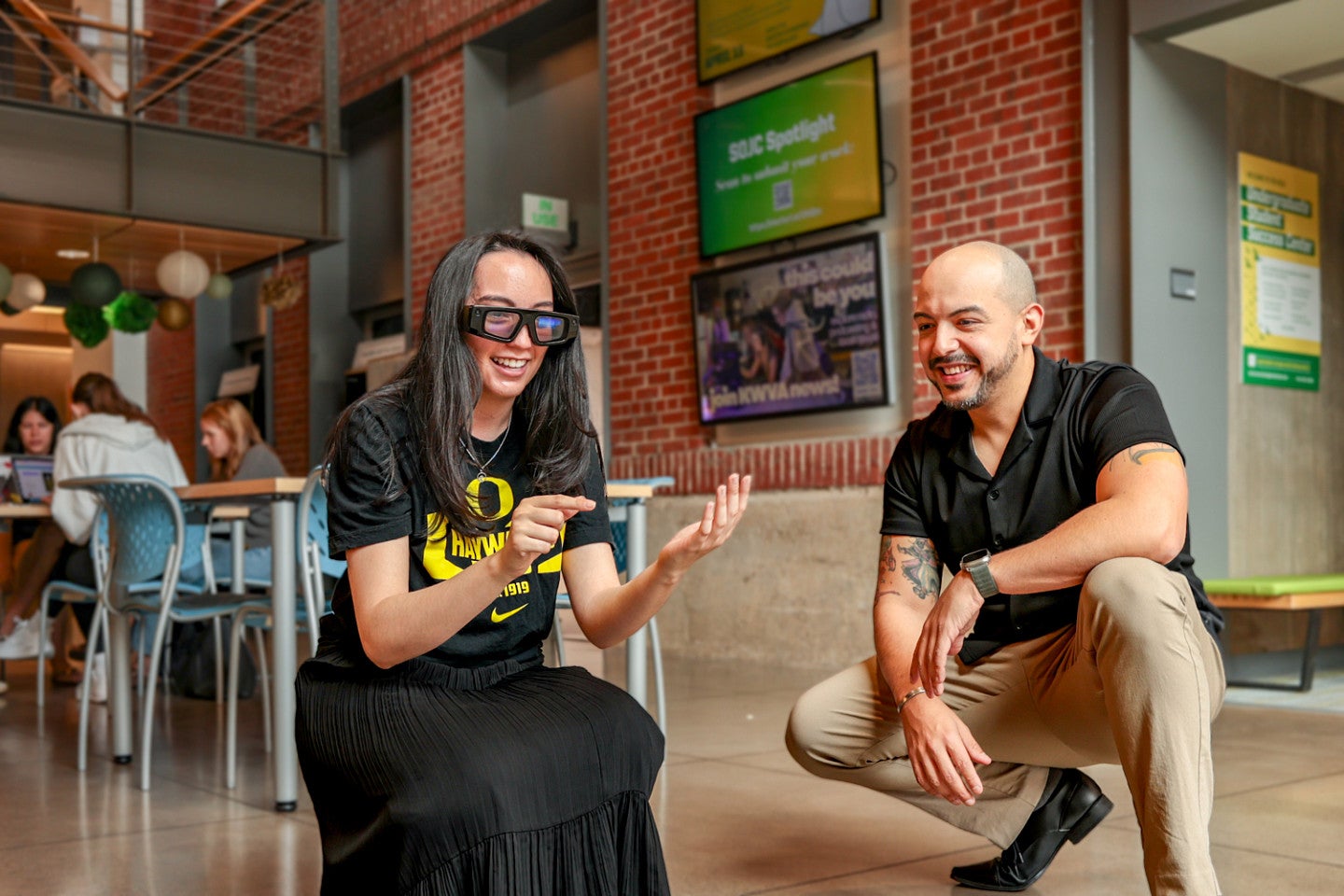 two people, one wearing Snap Spectacles, crouch down while testing an augmented reality lens