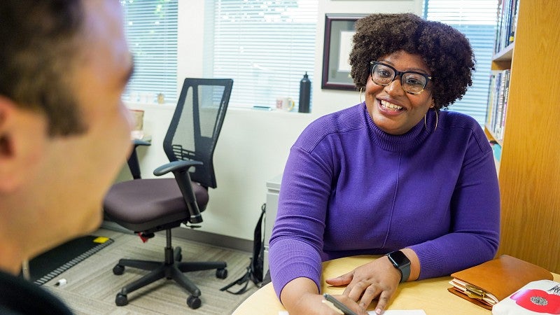 Dayna Chatman meets with a student in her office
