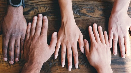 five hands flat on a table