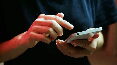 stock photo of a person's hands using a cell phone