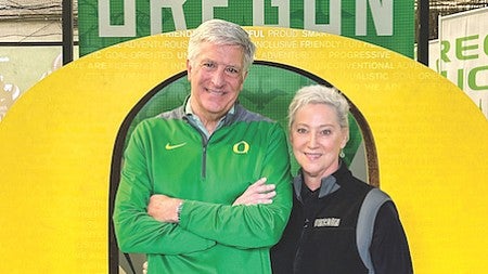 Eric and Betty Staniak pose in front of a large yellow O
