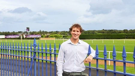 Jack Lazarus poses against a blue fence