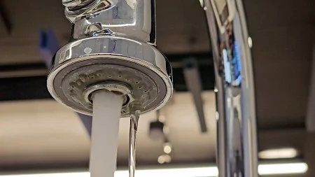 close-up of a standard faucet with running water