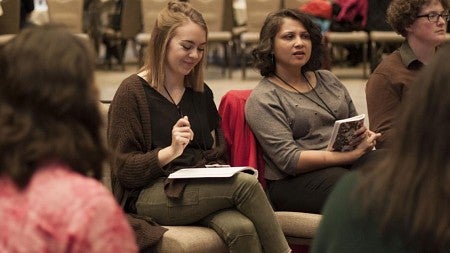 Women sitting with other students writing