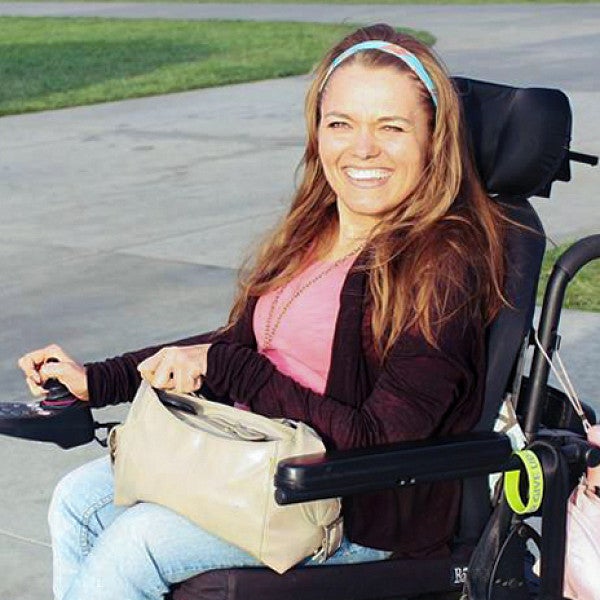 a portrait of Luda Gogolushko taken outside; Luda has long brown hair and is sitting in her wheelchair
