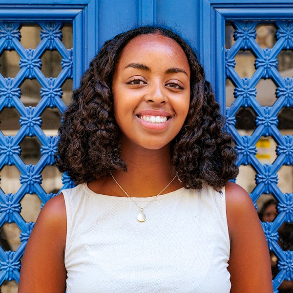 portrait of Hana Mazur in front of vibrant blue doors