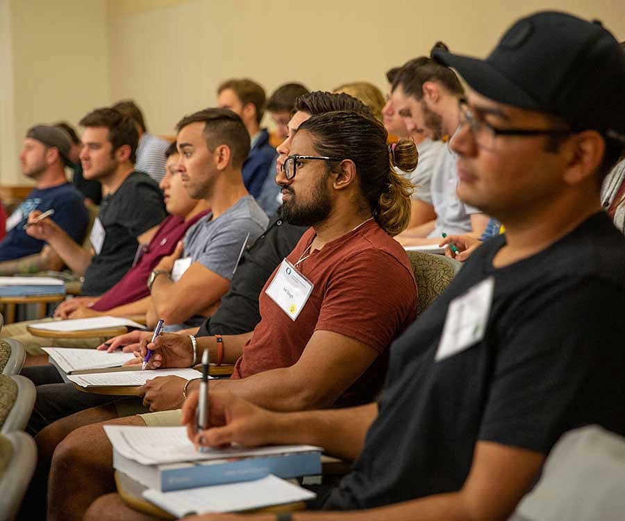 students taking notes in a lecture hall